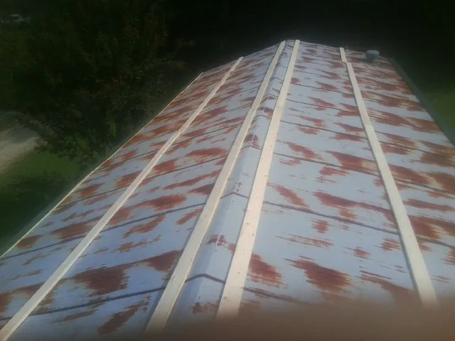 Rusted metal roof panels with new wood purlins before replacement — Storm Damage Roof Repair in Fort Leavenworth by Roofing Brothers