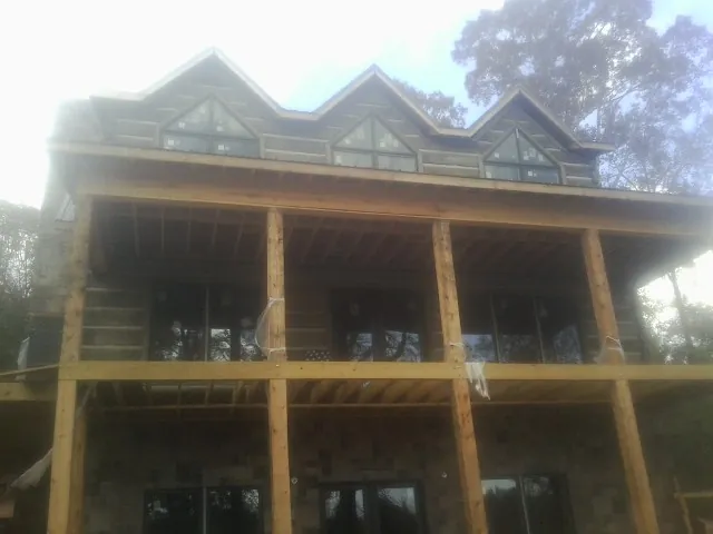 Dormers and porch framing on a large log home under construction — Roof Coating work by our crew in Fort Leavenworth