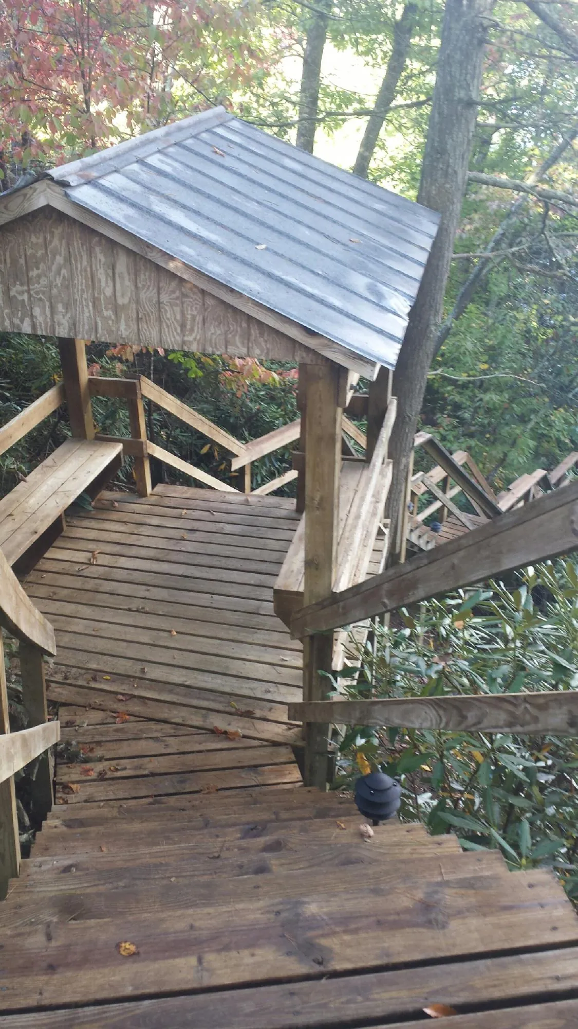 Metal roofed shelter over wooden steps on a wooded walkway — Skylight Repair & Installation work by our crew in Fort Leavenworth
