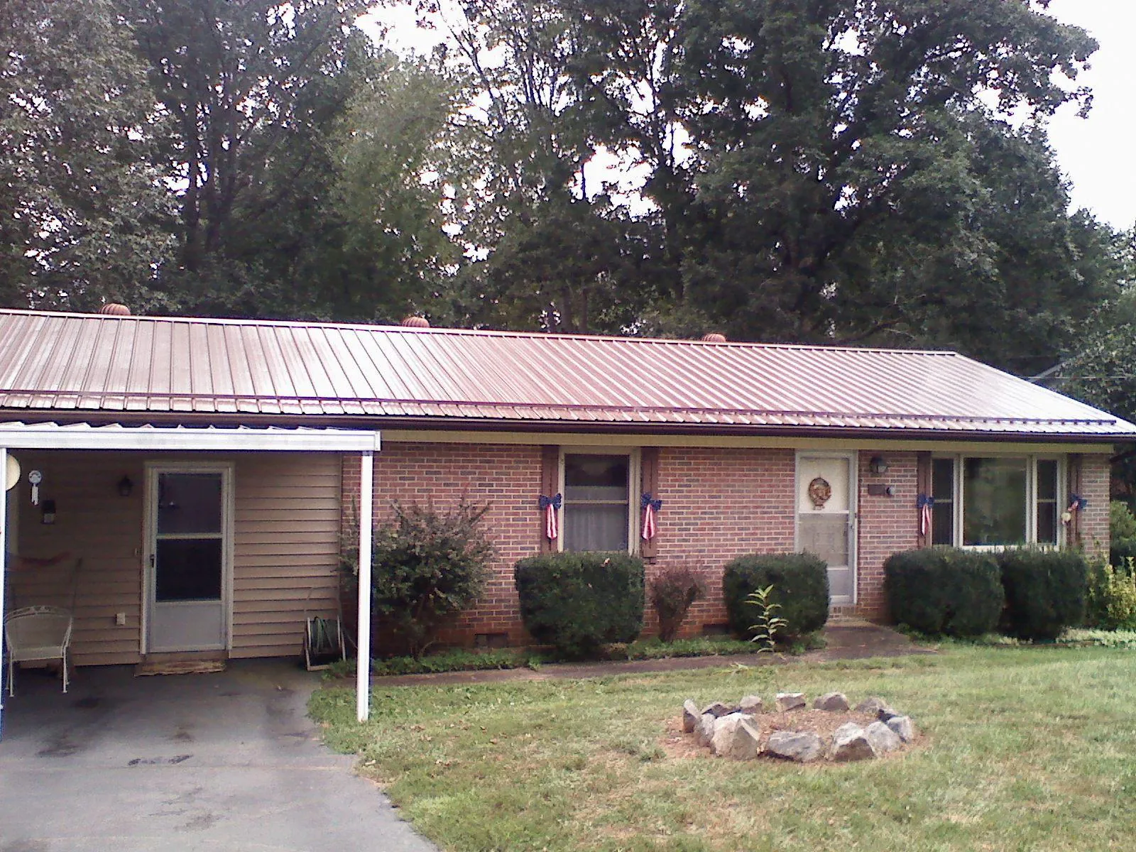 Bronze metal roof and carport on a brick ranch home — Roof Repair work by our crew in Fort Leavenworth